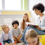 Teacher reading to preschool kids in a colorful classroom setting.